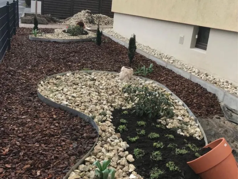 Beete mit Zierkies und Rindenmulch als Gestaltungselement an einer Einfahrt
