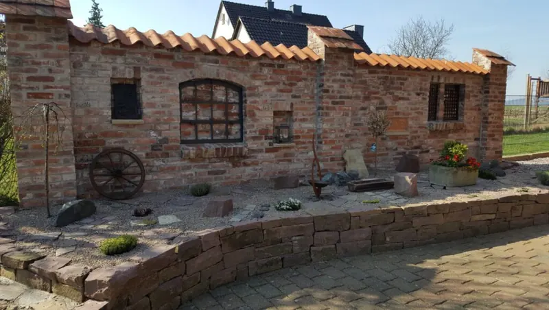 Gartenmauer aus Klinker mit rustikalen Deko-Akzenten